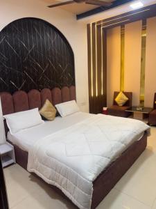 a bedroom with a large bed with a large headboard at Hotel American in Sahāranpur