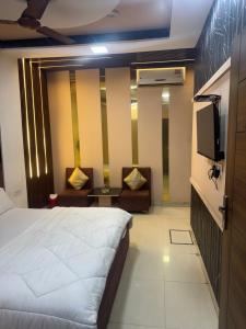 a hotel room with a bed and a flat screen tv at Hotel American in Sahāranpur