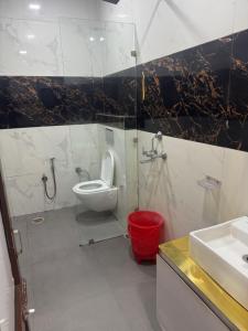 a bathroom with a toilet and a sink at Hotel American in Sahāranpur