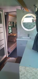 a small room with a sink and a mirror at Bus aménagé in Millas