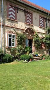 an old house with a grass yard in front of it at Schloss Höllrich in Karsbach