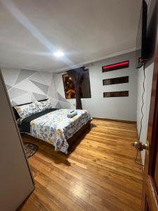 ein Schlafzimmer mit einem Bett und einem Holzboden in der Unterkunft Departamentos en Cuenca in Cuenca + 19 Fotos