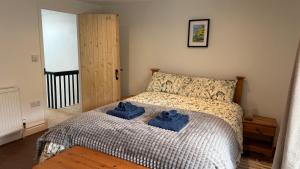 a bedroom with a bed with two blue towels on it at The Burrow in Kendal