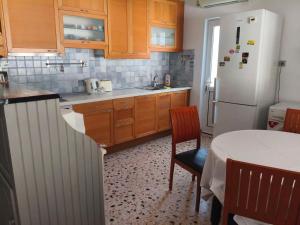 a kitchen with a table and a white refrigerator at Nicks house by zarkco in Artemida