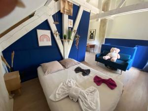 a bedroom with a bed and a chair with a teddy bear at Le Pivoine in Gury +2 photos