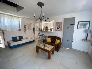 a living room with a couch and a table at Le Pivoine in Gury