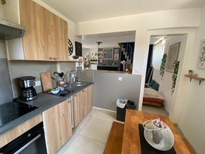 a kitchen with wooden cabinets and a wooden table at Le Pivoine in Gury