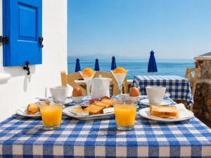 a table with plates of food and orange juice at Dream Island Hotel in Livadia