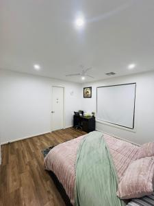 a white room with a bed and a screen at Mickleham Prestige Homestay in Mickleham