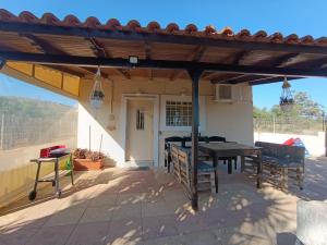 a patio with a table and chairs under a pergola at Olive Grove Cottage Skalani in Knossós