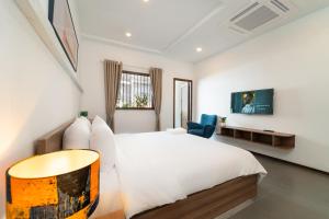 a bedroom with a white bed and a blue chair at 5BR Home - BBQ - City Centre - Free Pick Up for 3 nights in Ho Chi Minh City
