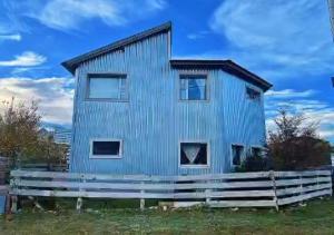 a blue house with a fence in front of it at Hostel Acuarelas in El Chalten