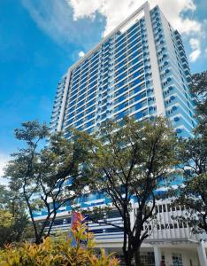 a tall white building with trees in front of it at The Loop North Tower in Cagayan de Oro