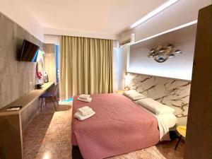 a hotel room with a bed and a desk at Peter's Place Studios & Suites in Faliraki +58 photos
