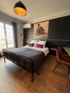 a bedroom with a large bed with a painting on the wall at Gîtes et Chambres Atypiques Le Temps des Légendes in Saint-Quentin-la-Poterie +37 photos