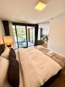 a large white bed in a room with a living room at Heyko Holiday Interlaken in Interlaken
