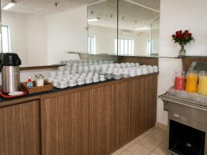 a counter with a bunch of white cups on it at Hotel Internacional São Paulo in São Paulo