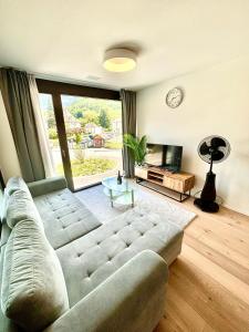 a living room with a couch and a large window at Heyko Holiday Interlaken in Interlaken