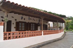 a white building with a fence on a street at Casa Mercedes in Agulo