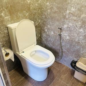 a bathroom with a toilet with a shower in it at Mini hotel in centre in Yerevan +18 photos