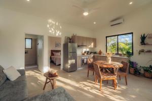 a living room with a table and a kitchen at Villa Ticalma in Parrita