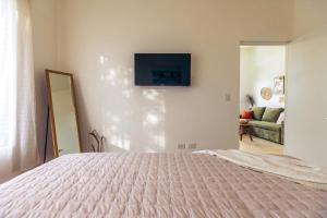 a bedroom with a bed and a television on a wall at Villa Ticalma in Parrita