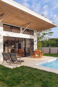 a house with a patio and a swimming pool at Villa Ticalma in Parrita