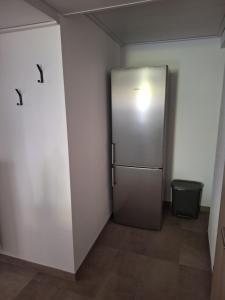 a large silver refrigerator in a room with a trash can at Das kleine SOTEL in NuÃŸbaum