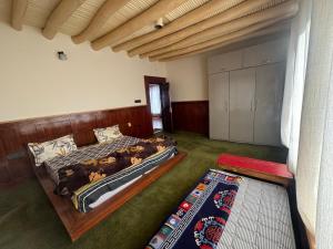 a bedroom with a bed with a wooden headboard at Cho Farm House in Leh