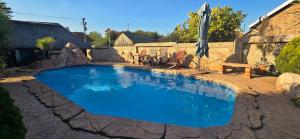 a large blue pool with chairs and an umbrella at GerSan Oasis in Nigel