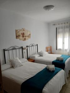 a bedroom with three beds with blue sheets at Portal 17 Can Tort in Tossa de Mar