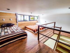 a bedroom with two beds and a staircase in it at Casa Argentina in San Juan La Laguna