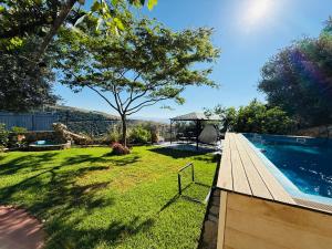 a backyard with a swimming pool and a grass yard at The Sky Zimmer in Ein Kinya +57 photos