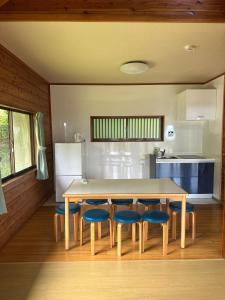 a kitchen with a table and some blue chairs at Maruta なんもく村 in Minamimaki +25 photos