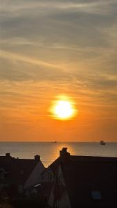 a sunset over the ocean with the sun in the sky at Sunset Bed and Breakfast in Broad Haven