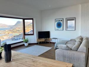 a living room with a couch and a tv at The Lookout - Spacious 2 bed overlooking Kalk Bay in Kalk Bay