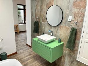 a bathroom with a green sink and a mirror at The Lookout - Spacious 2 bed overlooking Kalk Bay in Kalk Bay +22 photos