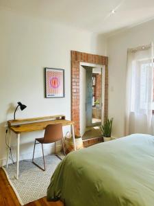 a bedroom with a desk and a bed at The Lookout - Spacious 2 bed overlooking Kalk Bay in Kalk Bay