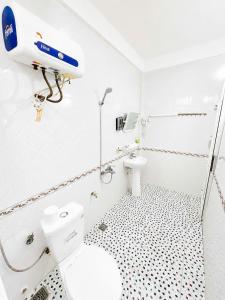a white bathroom with a toilet and a sink at Hoa Phuong Hotel Phong Nha in Phong Nha +33 photos