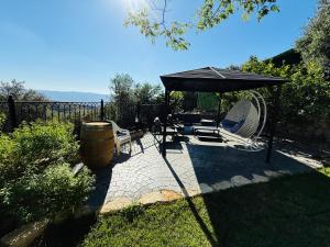 a patio with a black umbrella and chairs and a barrel at The Sky Zimmer in Ein Kinya