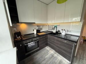 a kitchen with black counters and white cabinets at Gallo Riga Apartments in Riga