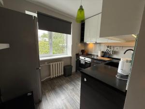 a kitchen with black counter tops and a window at Gallo Riga Apartments in Riga +2 photos