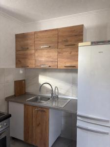 a kitchen with a sink and a white refrigerator at DM Apartman in Foča