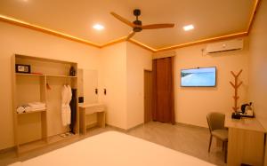 a bedroom with a ceiling fan and a desk at Maako Retreats in Milandu