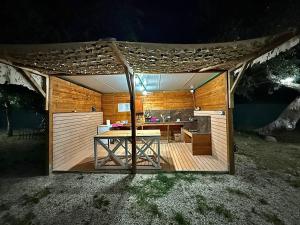 a wooden gazebo with a table in a backyard at Bocana Camping Borsh in Borsh