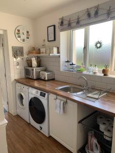 a kitchen with a washing machine and a sink at Country house in Svidník