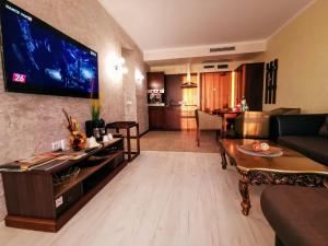 a living room with a couch and a tv on a wall at Royal Beach Premium Residence- Sunny Beach in Sunny Beach