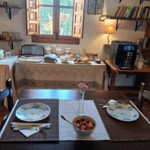 a table with plates and a bowl of fruit on it at Escuela La Crujía in Vélez-Málaga