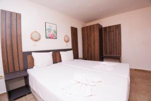 a bedroom with a large bed with white sheets at Hotel Arsenal in Nesebar