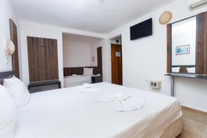 a white bedroom with a large white bed at Hotel Arsenal in Nesebar